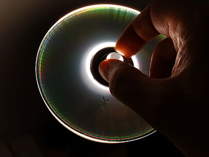 CD, DVD, Daten, Datenspeicher, Hand, Zugriff, Datenträger, Diskette, Computer, lichtspiel, Hintergrundbeleuchtung, menschliches Körperteil, menschliche Hand, eine Person, Körperteil, drinnen, Studioaufnahme, Nahansicht, Kreis, berühren, halten, menschlicher Finger, Geometrische Figur, Finger, gestalten, schwarzer Hintergrund, Kugel, Mitte Erwachsener, Erwachsene, 2K, CC0, gemeinfrei, lizenzfrei