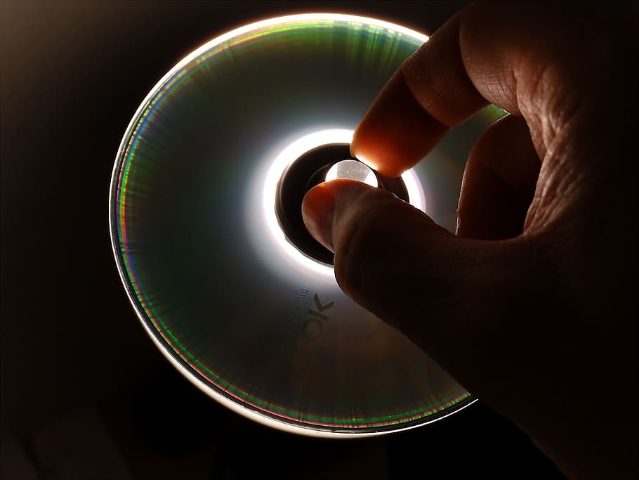cd, dvd, dades, botiga de dades, mà, accés, suport de dades, disquet, ordinador, lichtspiel, retroiluminació, part del cos humà, mà humana, una persona, part del cos, a l'interior, tir de l'estudi, primer pla, cercle, tocar, celebració, dit humà, forma geomètrica, dit, forma, fons negre, esfera, mig adult, adult, 2K