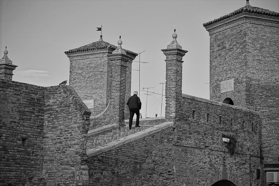comacchio, arquitectura, monument, estructura construïda, exterior de l'edifici, edifici, història, el passat, vista del darrere, persones reals, cel, una persona, turisme, destinacions de viatge, homes, dia, torre, activitat d'oci, naturalesa, viatjar, longitud completa, cel clar, a l'aire lliure, arc, paret de pedra, maó, 5K