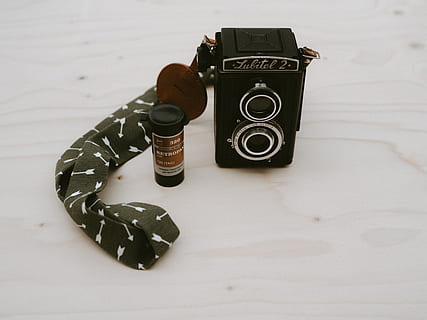 rectangular black camera, camera, electronics, strap, digital camera, video camera, shelf, blossom, flower, plant, beverage, alcohol, drink, lens cap, liquor, camera lens, display, screen, monitor, lcd screen, wood, photography themes, camera - photographic equipment, indoors, technology, still life, no people, photographic equipment, studio shot, close-up, high angle view, table, single object, retro styled, two objects, nostalgia, black color, antique, copy space, slr camera, 8K, CC0, public domain, royalty free