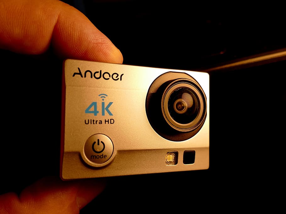 action cam, mini kamera, kamera, menneskelig hånd, hånd, menneskelig kropsdel, en person, tæt på, teknologi, kunstkultur og underholdning, kropsdel, bedrift, indendørs, menneskelig finger, finger, tekst, uigenkendelig person, vestlige script, musik, objektiv - optisk instrument, rigtige mennesker, fritidsaktivitet, personlige perspektiv, sort baggrund, 2K