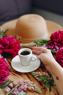 hvid keramisk krus, kop, kaffekop, keramik, underkop, tøj, beklædning, æg, mad, plante, blomst, blomstre, human, person, hat, solhat, blomster arrangement, pæon, dahlia, geranium, Rose, mad og drikke, friskhed, blomstrende plante, bord, menneskelig hånd, menneskelig kropsdel, krus, en person, hånd, drikke, rigtige mennesker, forfriskning, indendørs, selektiv fokusering, bedrift, lyserød farve, kropsdel, porcelæn, finger, menneskelig lem, 4K, CC0, offentligt domæne, royaltyfrie