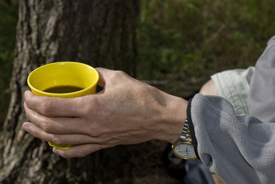 Kaffee, Kaffeepause, Kaffeebecher, Tasse, Getränk, Java, Kaffeetasse, dunkler Kaffee, Kaffeebohnen, Becher, Ausflug, Wald, eine Person, menschliche Hand, halten, Hand, menschliches Körperteil, Gelb, echte Menschen, Essen und Trinken, Lebensstile, Fokus auf den Vordergrund, Tag, Erfrischung, Freizeitbeschäftigung, draußen, Natur, Nahansicht, Finger, 4K