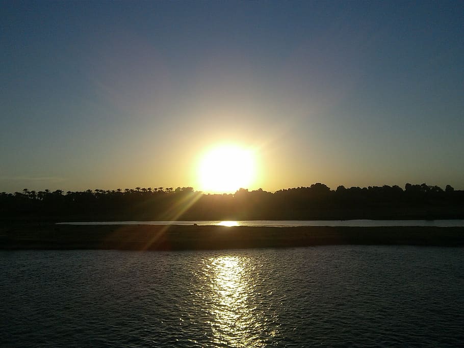 posta de sol, nil, Egipte, aigua, cel, llum solar, sol, tranquil·litat, escenics - natura, bellesa a la natura, escena tranquil·la, reflexió, flare de la lent, raig de sol, llac, silueta, naturalesa, idíl·lic, cap gent, davant del mar, escena no urbana, a l'aire lliure, brillant, 2K