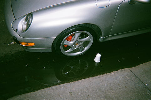 véhicule gris, véhicule, voiture, transport, pneu, roue, machine, jante en alliage, parlait, roue de voiture, 35mm, New York, Porsche, analogique, lumière, phare, enjoliveur, symbole, marque déposée, logo, mode de transport, véhicule à moteur, véhicule terrestre, personne, Voyage, vue grand angle, journée, ville, en plein air, voiture de sport, style rétro, rue, la nature, réflexion, fermer, couleur argentée, luxe, 2K, CC0, domaine public, libre de droits