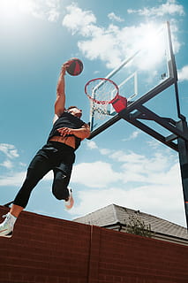 man performing dunk, person, human, sports, people, basketball, sport, apparel, footwear, clothing, shoe, team sport, team, outdoors, basketball court, dunk, sun, sunshine, nba, slam dunk, backyard, sky, architecture, low angle view, one person, leisure activity, real people, lifestyles, cloud - sky, jumping, built structure, basketball hoop, building exterior, basketball - sport, sunlight, full length, day, nature, mid-air, men, skill, lens flare, basketball - ball, arms raised, effort, 4K, CC0, public domain, royalty free