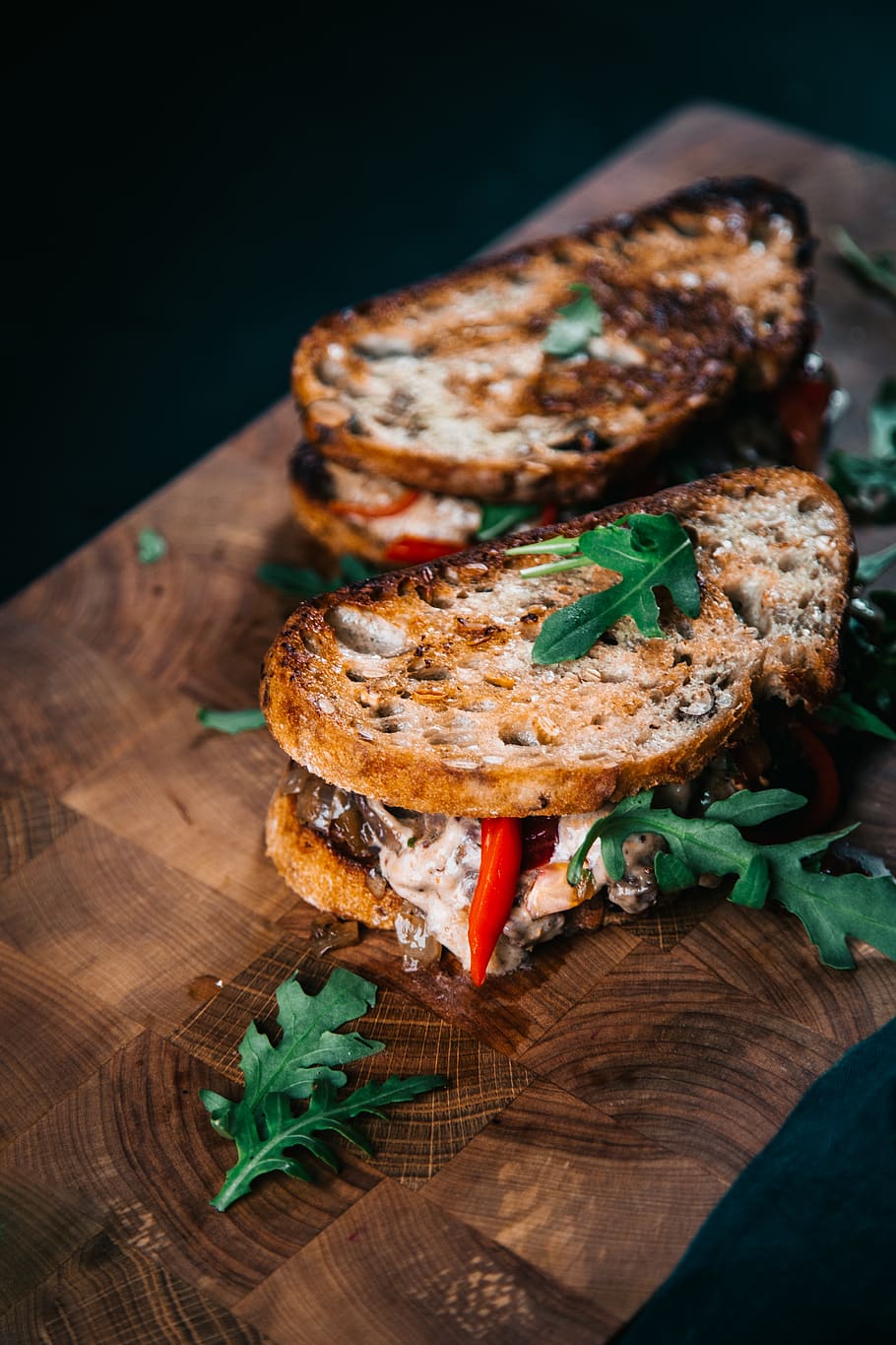 hamburguesa, planta, pa, vegetals, entrepà, menjar, condiment, produir, plat, rostit, albergínia, sopar, ruca, pa torrat a la francesa, brindis, bistec, nyam, moniato, menjar i beguda, frescor, llest per menjar, taula, a l'interior, alimentació saludable, primer pla, natura morta, taula de tallar, material de fusta, vista d’angle alt, cap gent, herba, benestar, centrar-se en primer pla, indulgència, temptació, decorar, fons negre, berenar, 4K